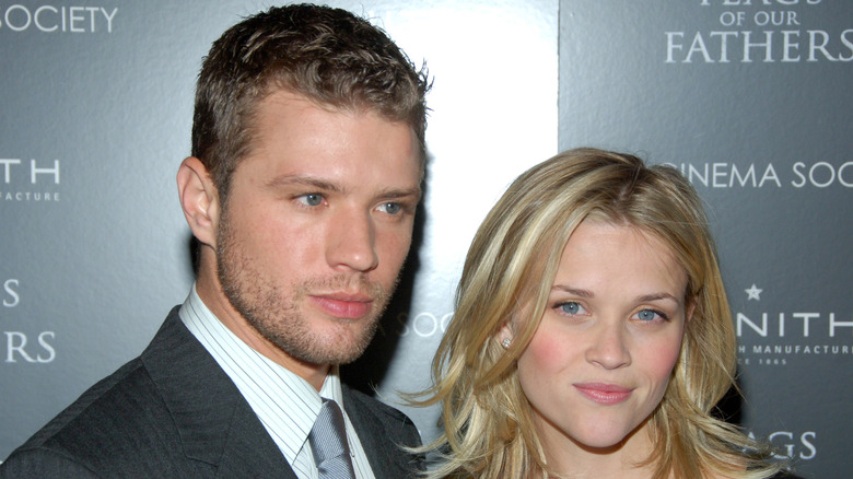 Ryan Phillippe wearing a grey suit, white shirt and silver necktie with Reese Witherspoon with blonde feathered hair