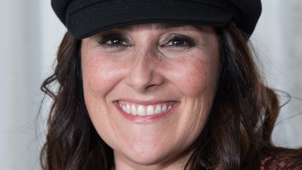 Ricki Lake posing in front of a curtain backdrop