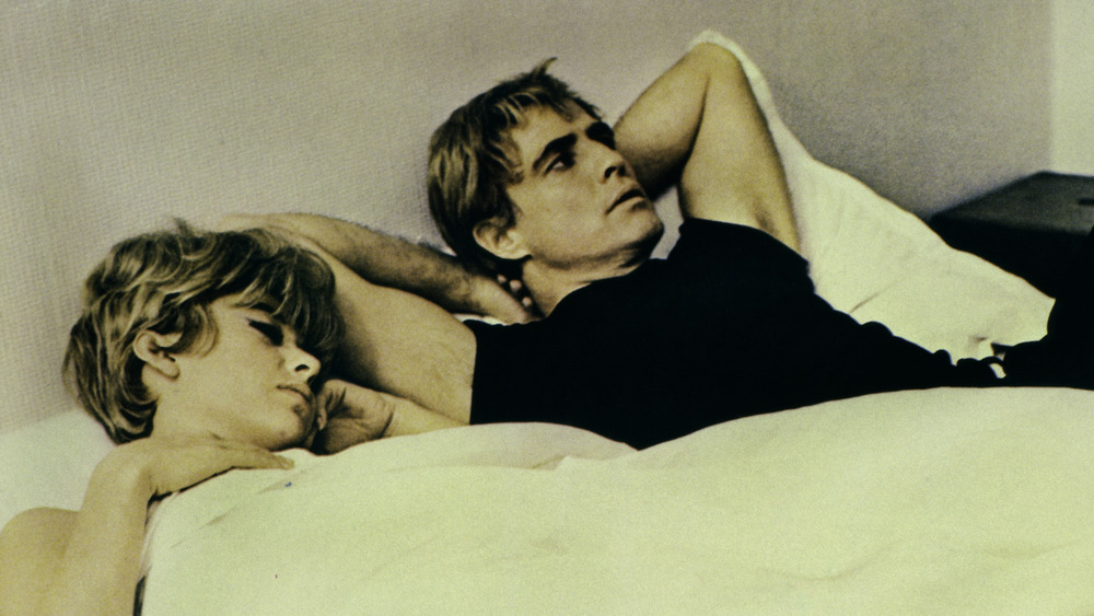 Rita Moreno and Marlon Brando lying in bed