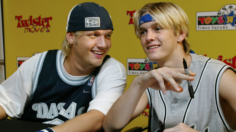 Nick Carter and Aaron Carter joking around while signing autographs