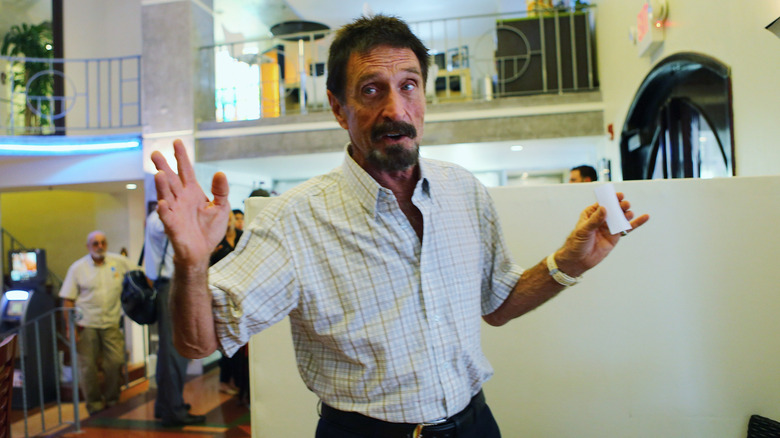 John McAfee holding his hands up