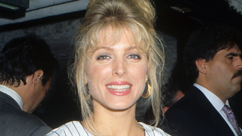 Marla Maples smiles with poofy hair