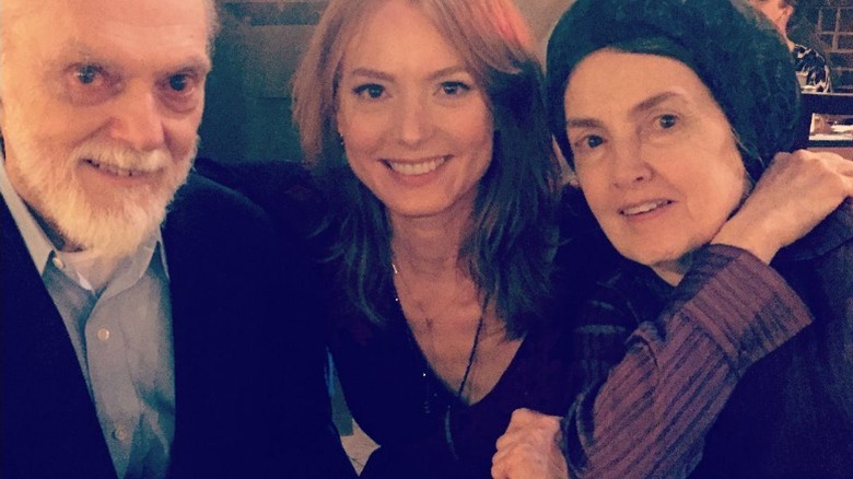 Alicia Witt smiles in a picture with her parents