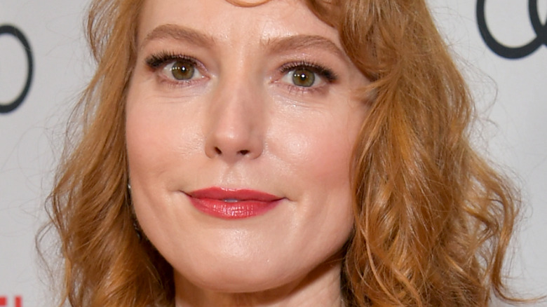 Alicia Witt gives a faint smile on the red carpet
