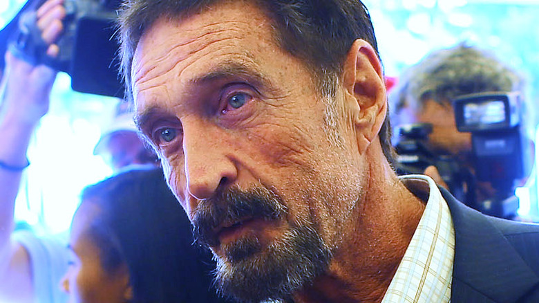 John McAfee in front of reporters