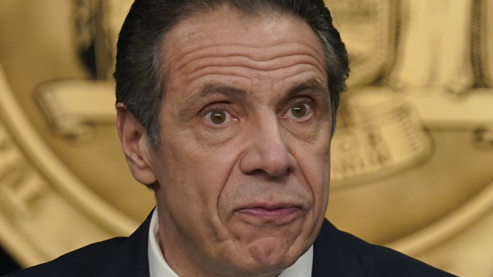 Andrew Cuomo seated at a press conference