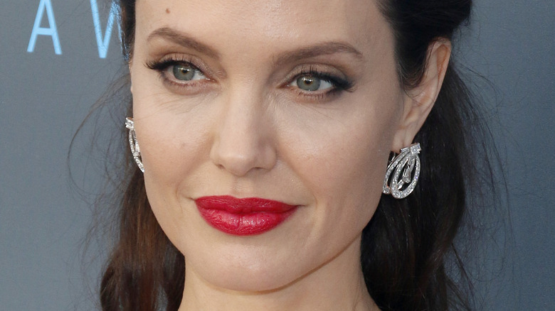 Angelina Jolie with red lipstick and slight smile on the red carpet