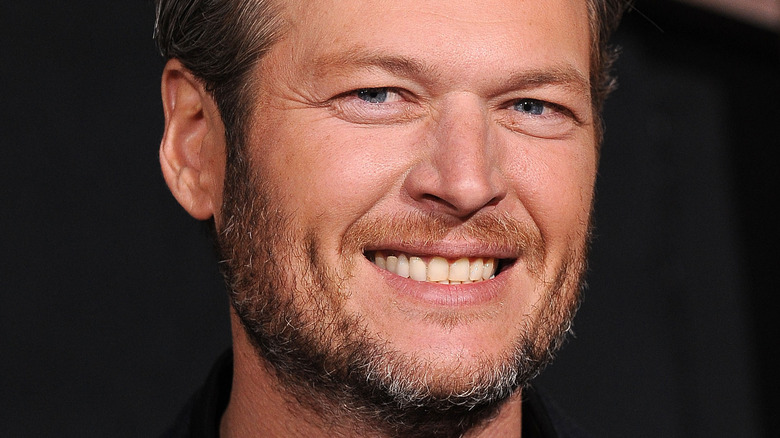 Blake Shelton smiles in a dark suit.