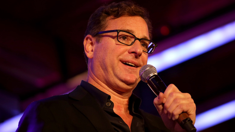 Bob Saget speaking into microphone
