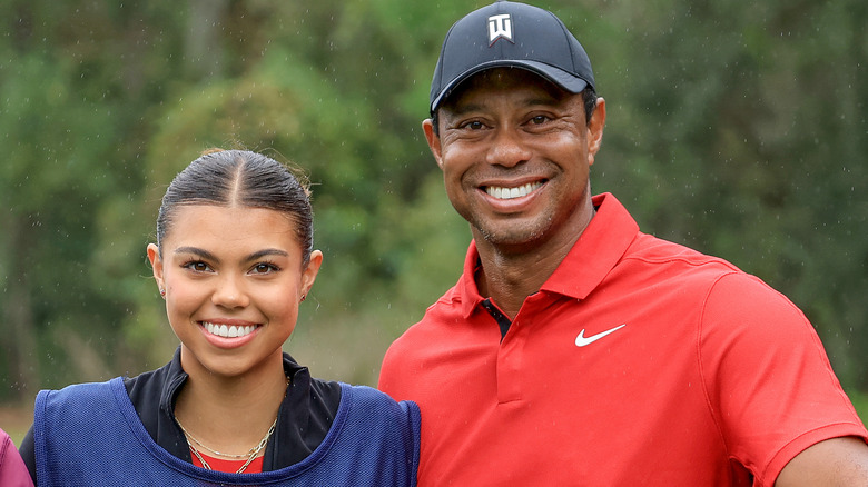 Sam Woods and Tiger Woods stand together smiling