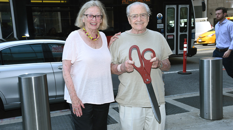 Bonnie Bartlett and William Daniels holding a giant pair of scissors