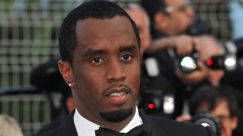 Sean Diddy Combs wearing a bow tie while photographers take pictures