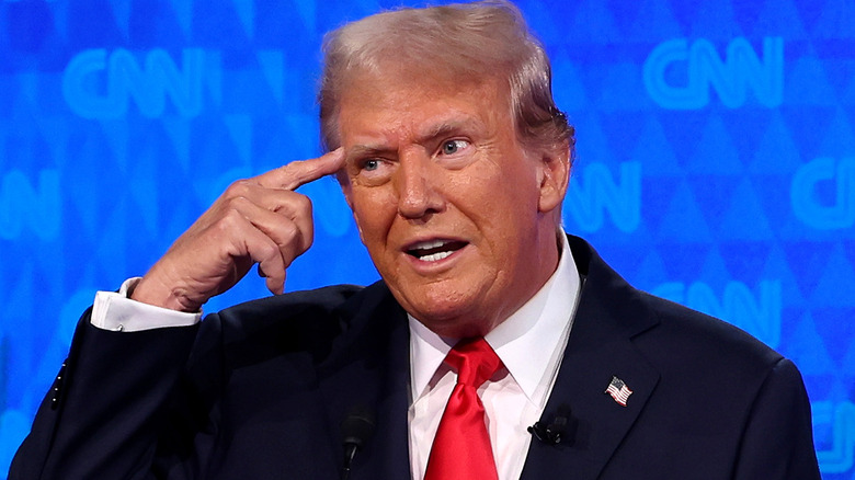 Donald Trump pointing at his head