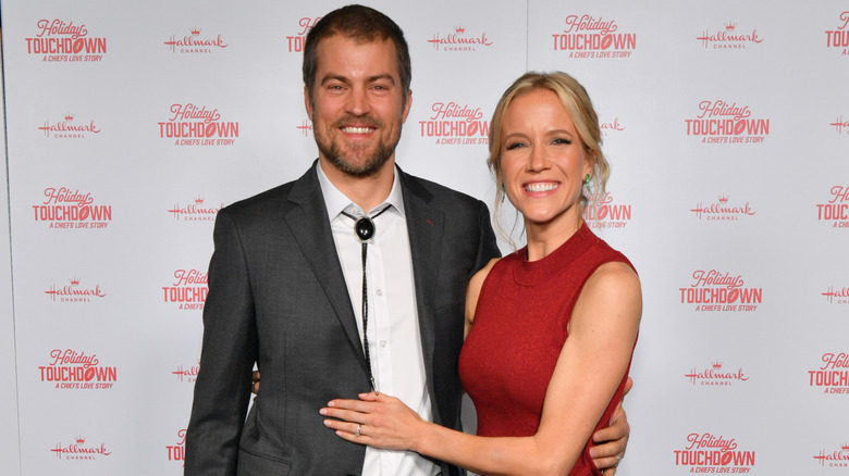 Jessy Schram smiling and posing with her hand on Sterling Taylor's stomach.