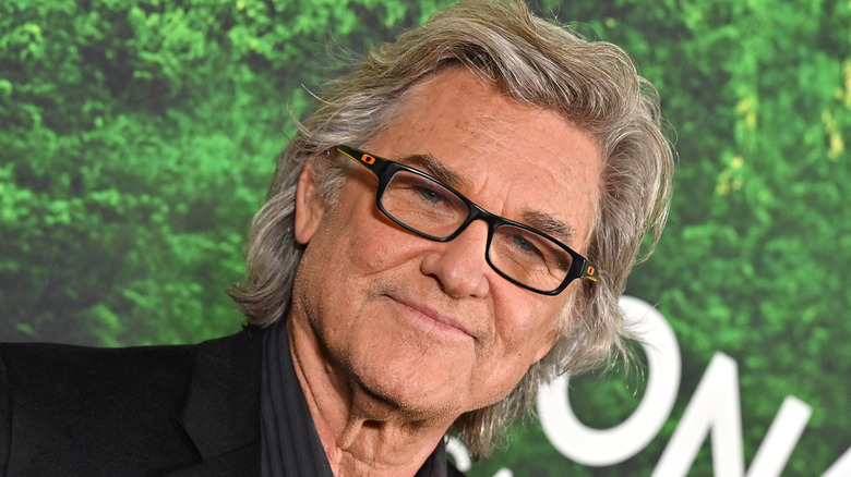 Kurt Russell poses in black-frame glasses in 2023