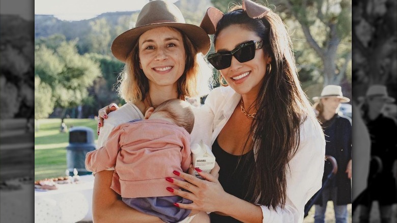 Troian Bellisario, baby Elliott Adams, and Shay Mitchell smiling