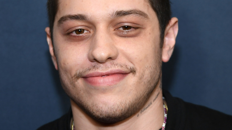 Pete Davidson poses in a black T-shirt