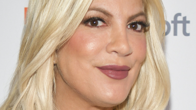 Tori Spelling smirking