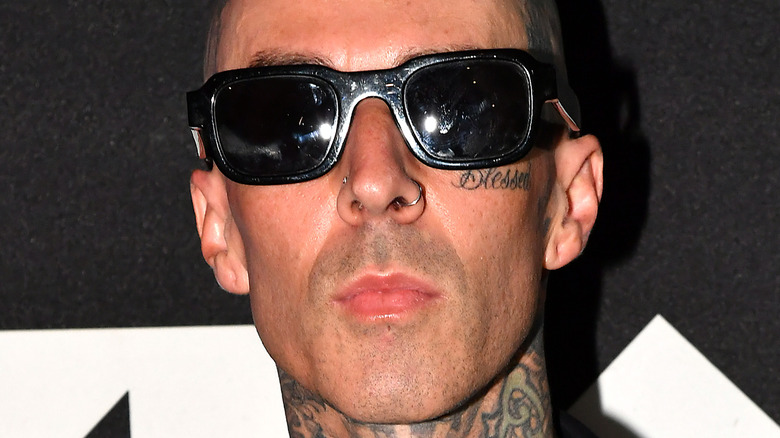 Travis Barker wearing black, rectangle shaped sunglasses