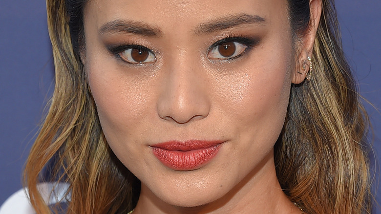 Jamie Chung poses in red-orange lipstick