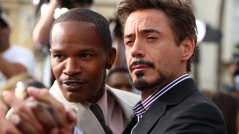 Jamie Foxx clasping hands with Robert Downey Jr.