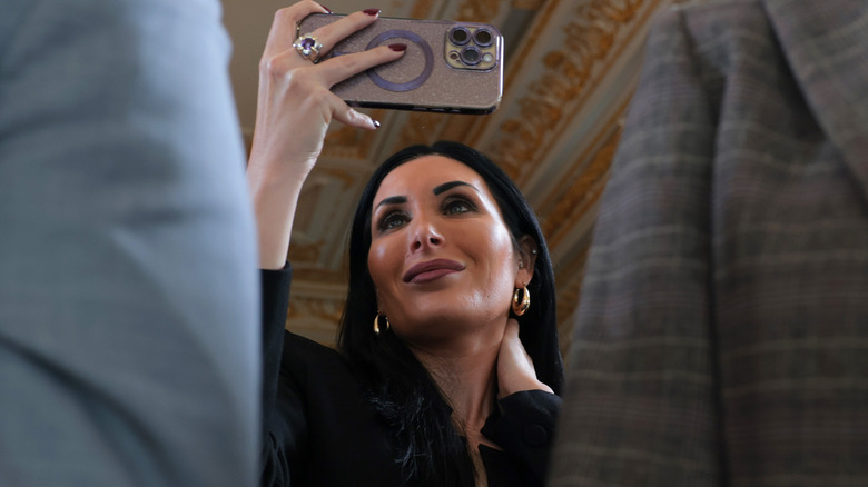 Laura Loomer holding up her phone