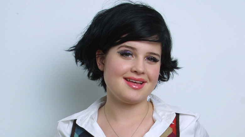 Kelly Osbourne smiling with short black hair
