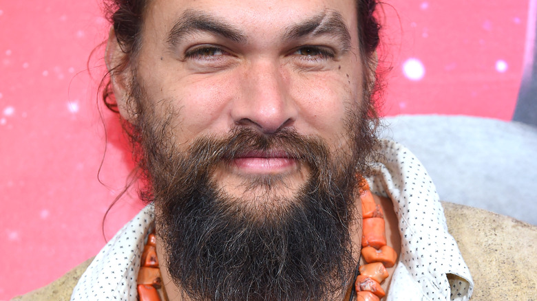 Jason Momoa smiling 2019 orange necklace