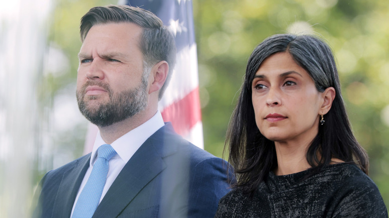 JD Vance and Usha Vance standing near an American flag outside