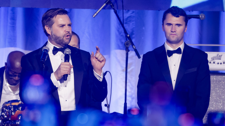 JD Vance speaking on stage with Charlie Kirk
