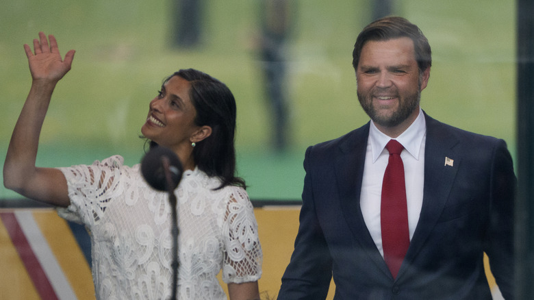 Usha Vance waving with JD Vance approaching podium military parade