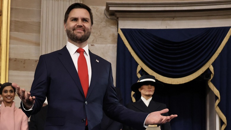 JD Vance smiling while wearing a red tie and dark blue suit at the president's inauguration.