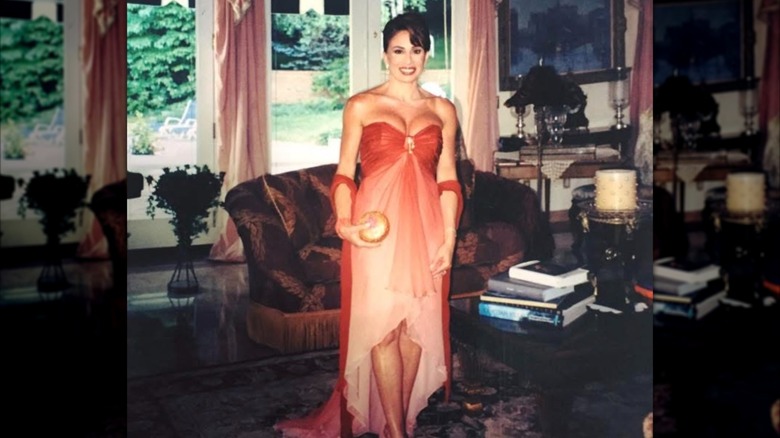 Jeanine Pirro posing for a photo before heading out to a fundraiser in a strapless red and pink dress with a low neckline.
