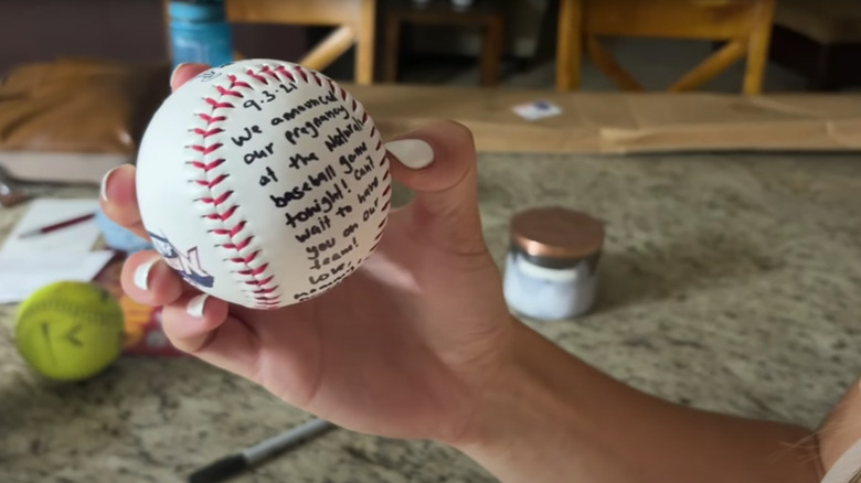 Katey Nakatsu holding baseball with pregnancy announcement