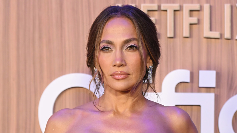 Jennifer Lopez wearing a strapless gown with floral appliques at the Office Romance premiere.