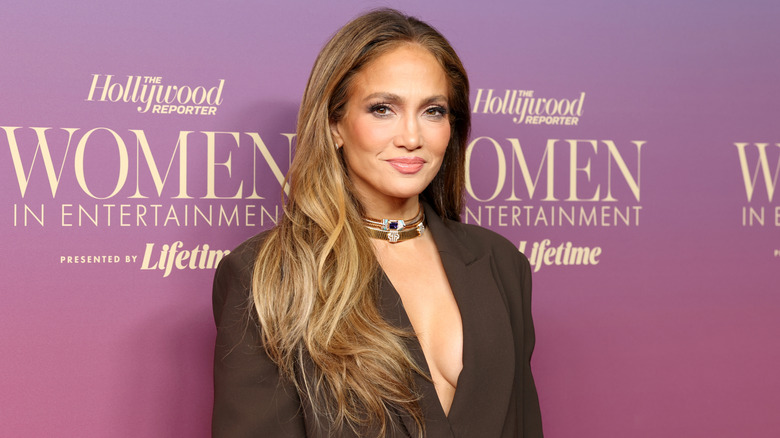 Jennifer Lopez wearing a brown dress and stacked choker necklaces.