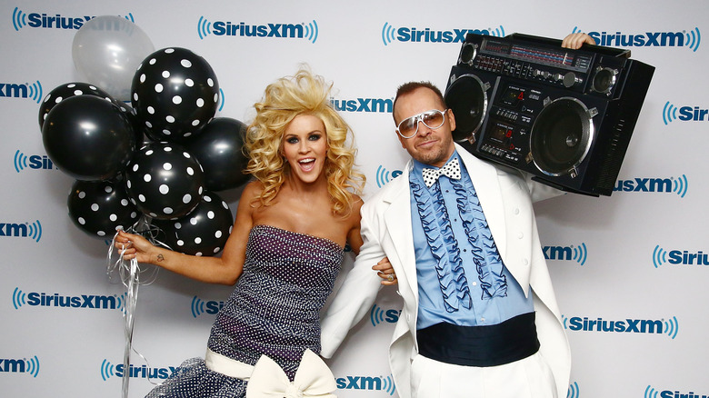 Jenny McCarthy holding balloons, Donnie Wahlberg holding boombox