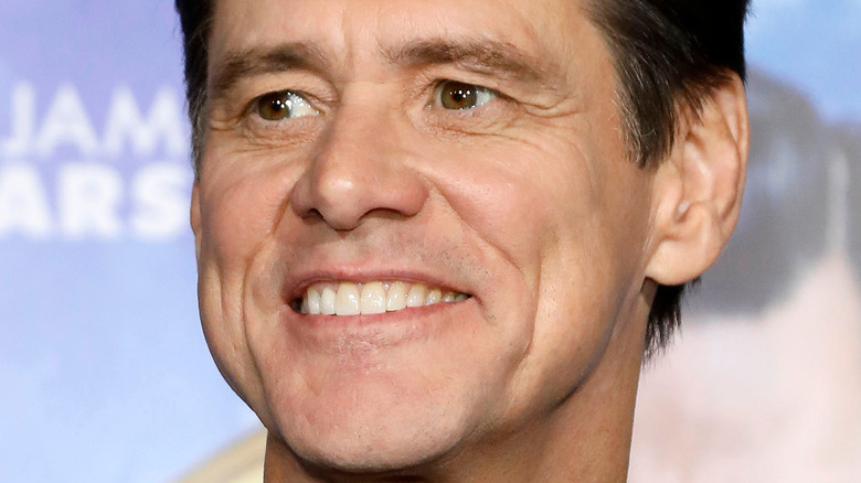 Jim Carrey looking to the side with a grin