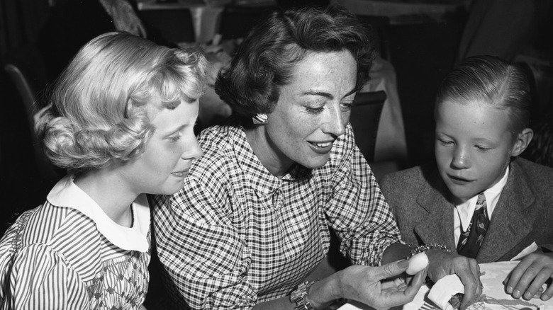 Joan Crawford pictured at a party with young Christina and Christopher Crawford.
