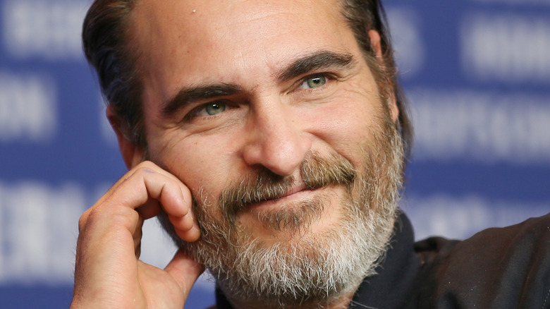 Joaquin Phoenix smiling away from camera