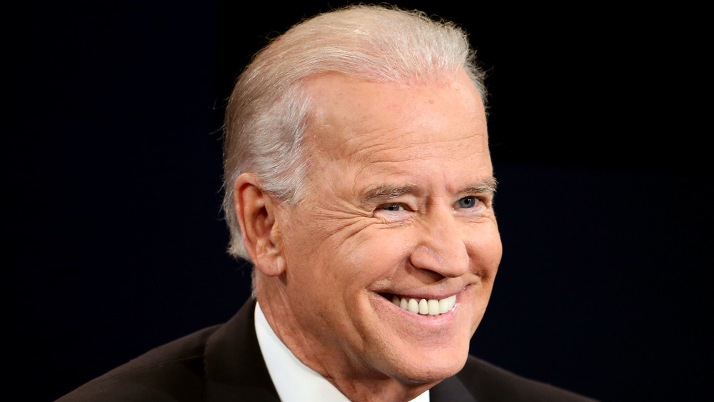 Joe Biden smiles while speaking at a conference