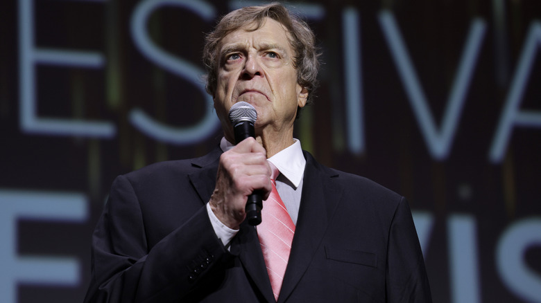 John Goodman speaking on stage at the Monte Carlo TV Festival.