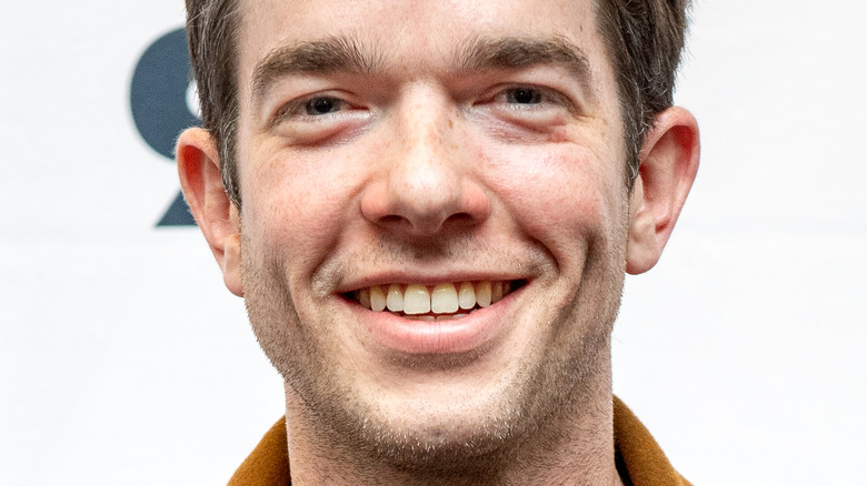 John Mulaney smiles at an event