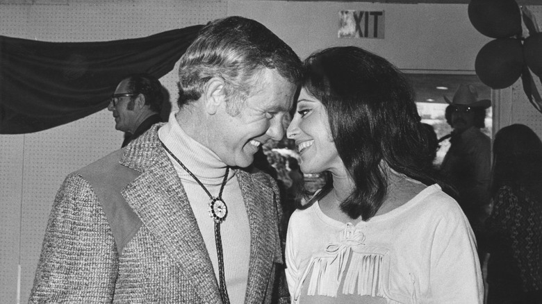 Johnny Carson and Joanna Holland smile with their foreheads together