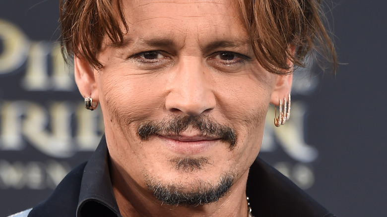 Johnny Depp walks the red carpet with multiple earrings