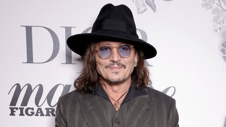 Johnny Depp wearing a fedora and glasses 
