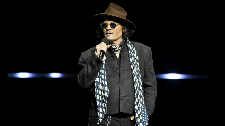 Johnny Depp wearing a brown wide-brimmed hat and blue and white polka-dot scarf at Cinemacon.