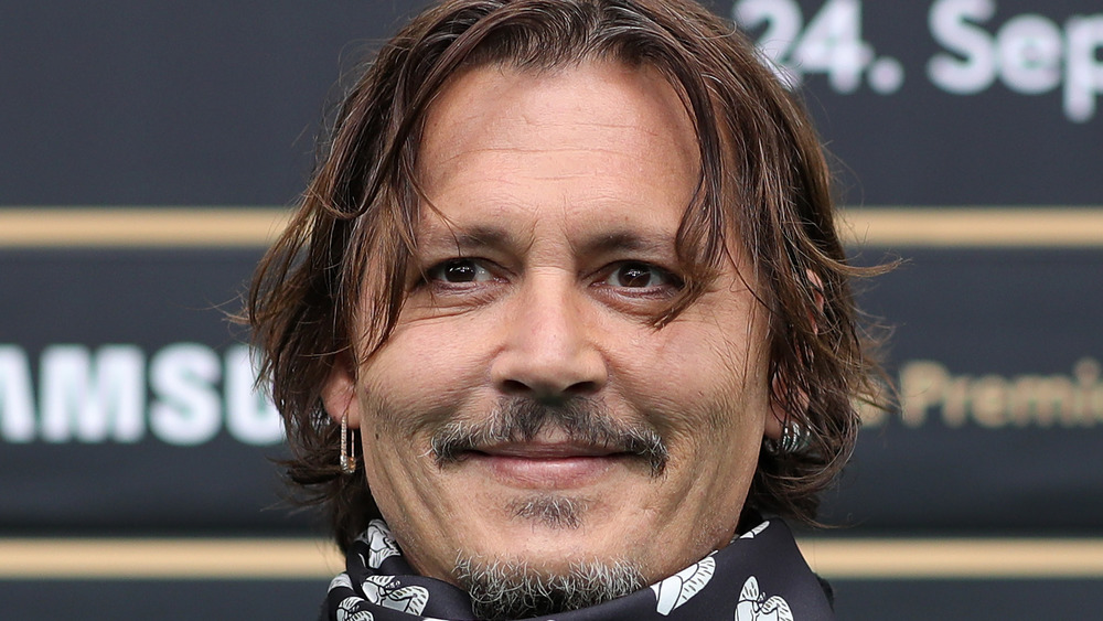 Johnny Depp smiling wearing earrings