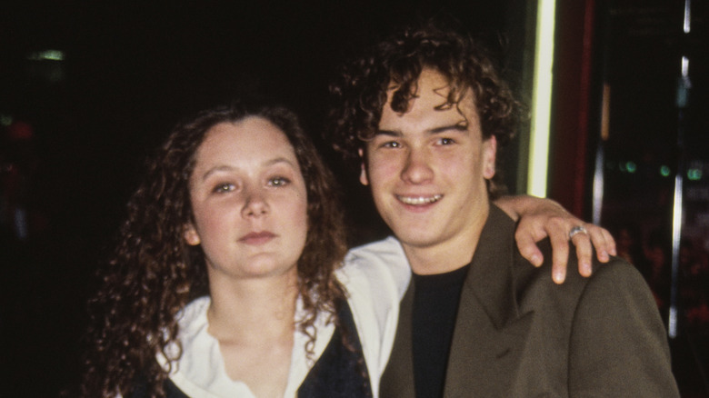 A young Johnny Galecki and Sara Gilbert posing on step-and-repeat
