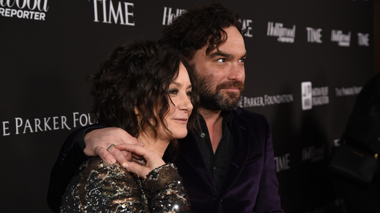 Sara Gilbert and Johnny Galecki posing on step-and-repeat